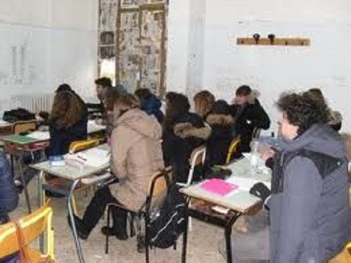 Troppo freddo a scuola studenti in classe con il cappotto