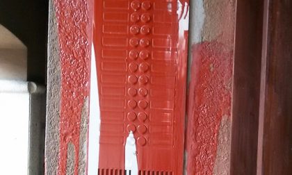 Vandali in azione, vernice rossa lanciata contro i citofoni di un condominio
