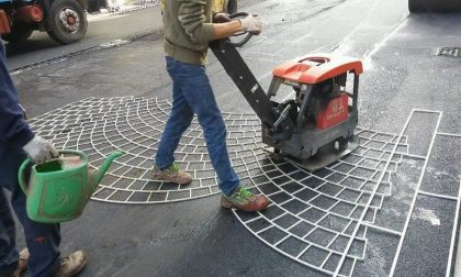 Restyling di via Zavattari: operai al lavoro per posare l'asfalto "stampato"