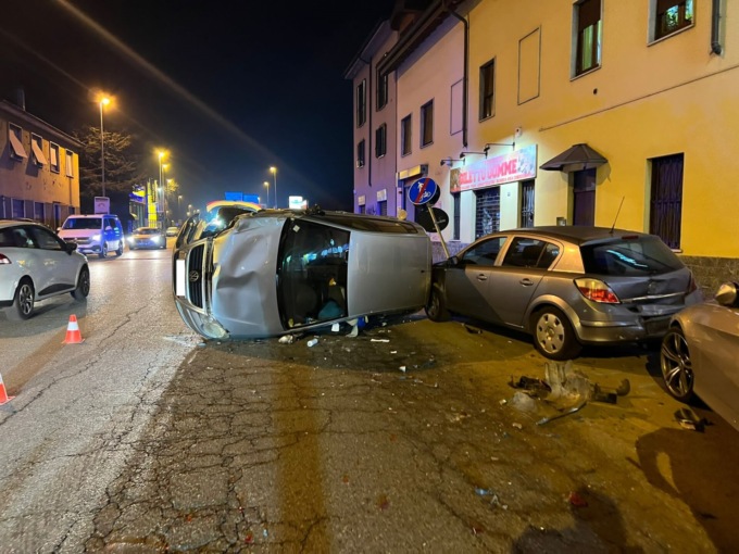 Si schianta contro le auto in sosta e si ribalta