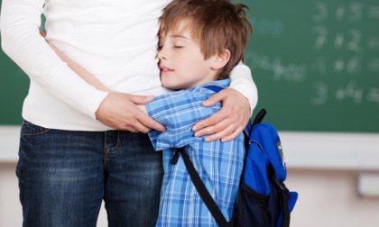 Padre picchia il figlio davanti alla maestra, che si mette in mezzo e lo protegge