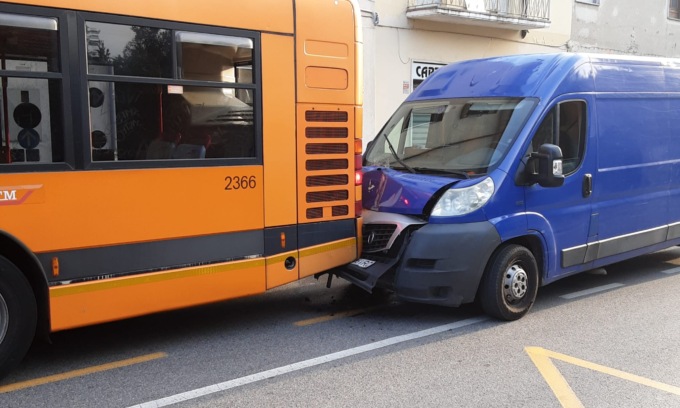 Furgone tampona autobus di linea con passeggeri a bordo