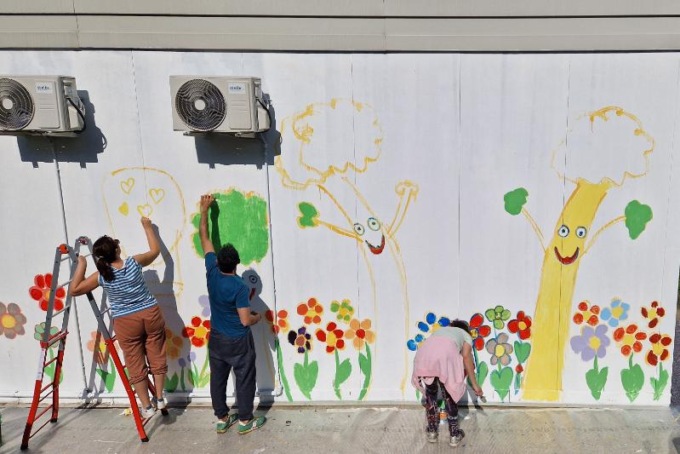 Alberi e fiori sui muri del prefabbricato
