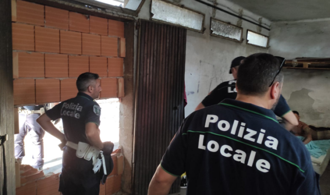 Abbatte la porta murata per occupare il locale