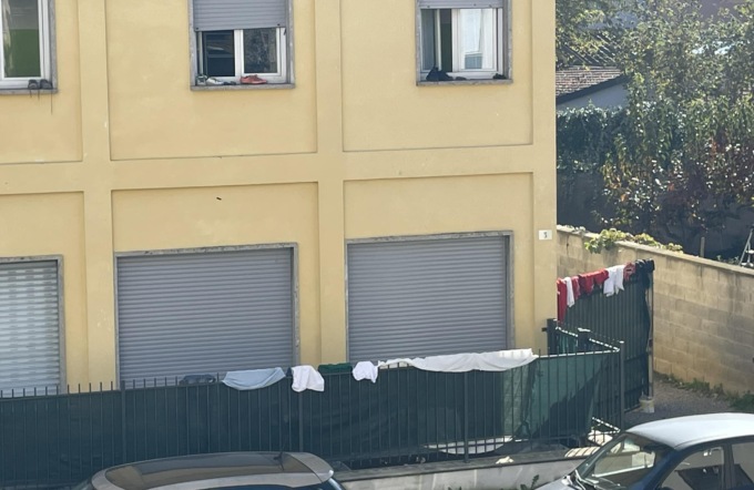 I richiedenti asilo stendono i panni sulla cancellata. L’assessore regala loro uno stendibiancheria