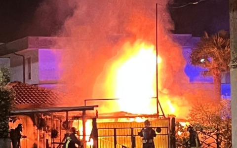 Va a fuoco una automobile posteggiata vicino a dei box